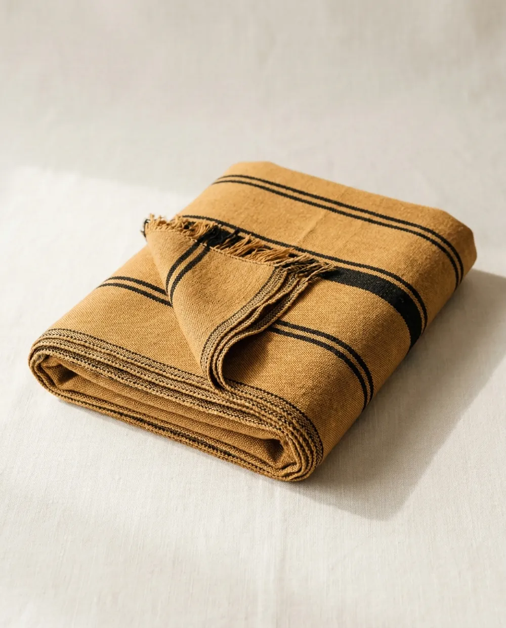 Folded ochre and black Maasai shuka